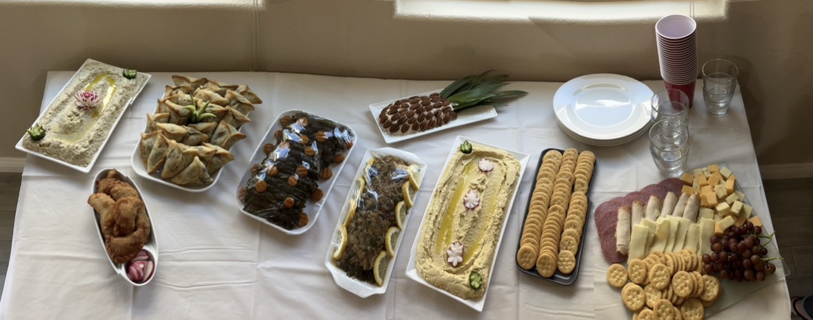 Mama Love's authentic Lebanese catering spread with hummus, sambousek, stuffed grape leaves, and a cheese board